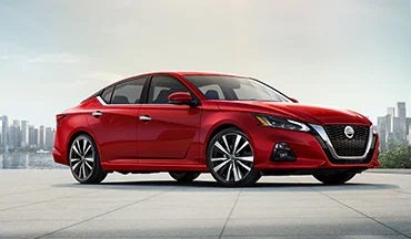 2023 Nissan Altima in red with city in background illustrating last year's 2022 model in Wood Nissan of Lee's Summit in Lee's Summit MO